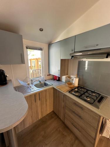 a kitchen with a sink and a stove top oven at Large Mobile Home on 4star Camping in Capbreton