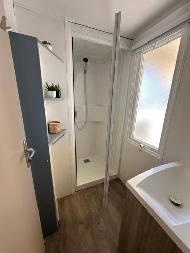 une salle de bain avec douche et lavabo dans l'établissement Large Mobile Home on 4star Camping, à Capbreton