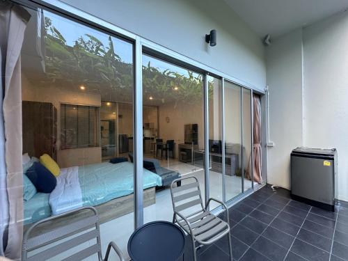 a bedroom with a bed and a balcony at Chic Condo Karon Beach in Karon Beach