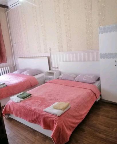 two beds in a bedroom with red sheets and towels at Ланжероновская угол Дерибасовская in Odesa
