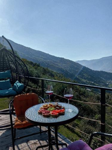 a table with two glasses of wine and a roller coaster at The overlook cottage 2 in Keda