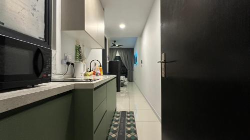 cocina con fregadero y puerta negra en Cozy Studio Kuala Lumpur by LH, en Kuala Lumpur