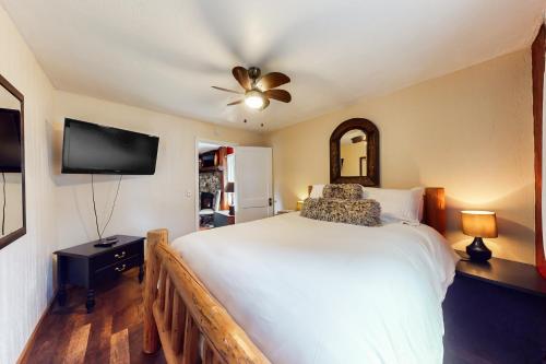a bedroom with a white bed and a flat screen tv at Honors Nook in Joseph