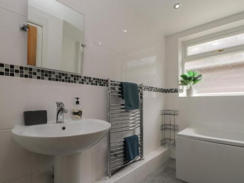 a white bathroom with a sink and a mirror at 6 Sydney Road in Ramsgate