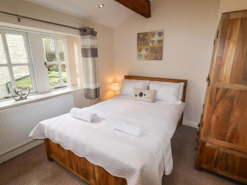 um quarto com 2 camas e uma janela em Erin Cottage formerly Chloe's Cottage em Keighley