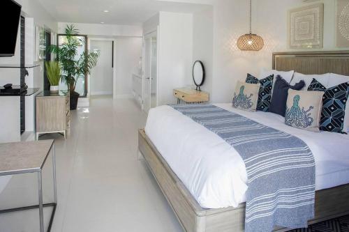 a bedroom with a large bed with blue and white pillows at Casa Grande - Grace Bay Beach in The Bight Settlements
