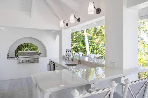 a white kitchen with a sink and a window at Casa Grande - Grace Bay Beach in The Bight Settlements