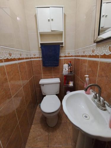 a bathroom with a toilet and a sink at Habitación 1, 2 Camas Individuales in Matamoros