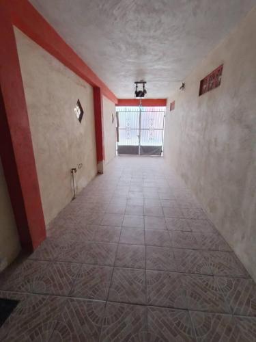 een lege kamer met een groot raam en een tegelvloer bij Habitación 1, 2 Camas Individuales in Matamoros