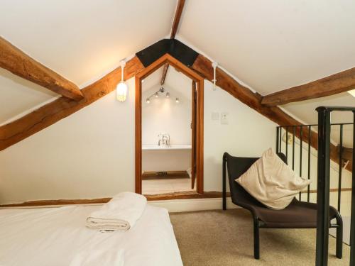 a bedroom with a mirror and a bed and a chair at Saddleback Barn in Penrith