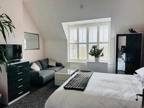 a bedroom with a bed and a couch at Penthouse Suite, Central St Leonards, Sea View in St. Leonards