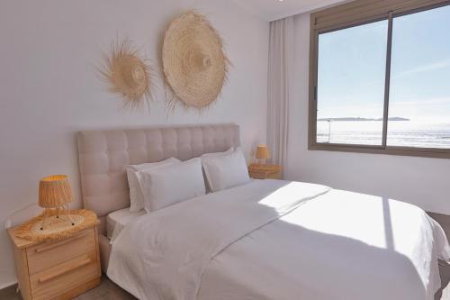 a bedroom with a white bed and a window at My Home in Essaouira in Essaouira