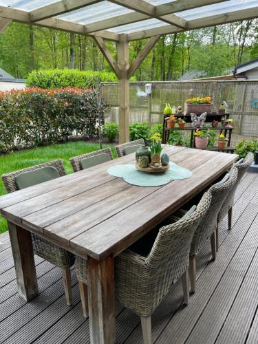 una mesa de madera y sillas en una terraza en Chalet Sint-Hubertus Du Bois en Zutendaal