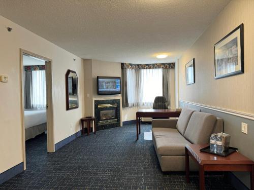 a living room with a couch and a fireplace at Divya Sutra Plaza and Conference Centre Calgary Airport in Calgary