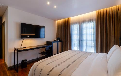 a hotel room with a bed and a flat screen tv at El Bodeguero Hotel in Salta