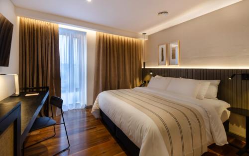 Habitación de hotel con cama grande y escritorio. en El Bodeguero Hotel en Salta
