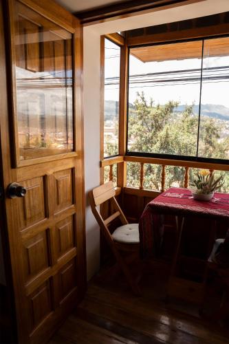 a room with a table and a chair and a window at Casa Antade Cusco in Cusco