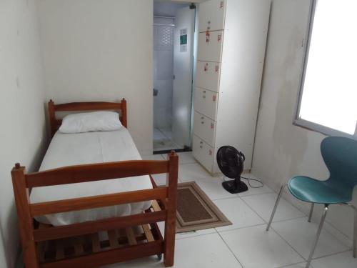 een slaapkamer met een bed, een stoel en een raam bij Hostel Arena Prime in Salvador