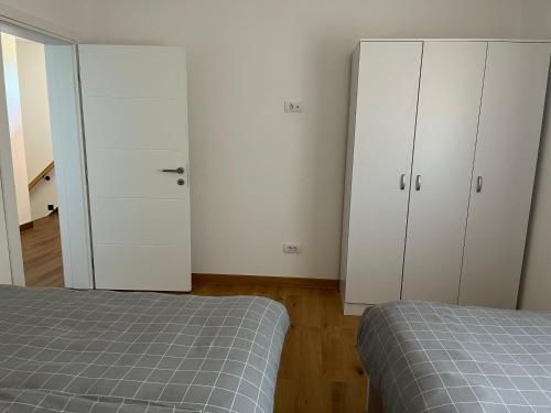 a bedroom with two white cabinets and a bed at Vip kuca Banja Vrujci in Popadić