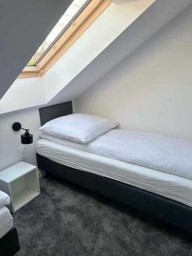 a small bedroom with a bed and a window at Marina Domki Apartamentowe in Jastarnia