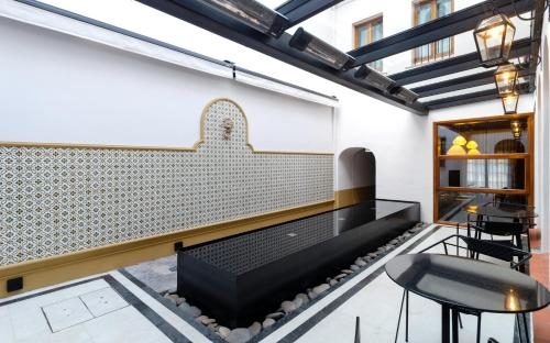 a room with a bench and tables and chairs at El Bodeguero Hotel in Salta