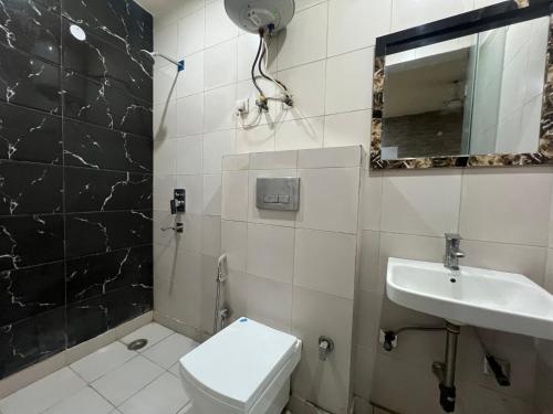 a bathroom with a toilet and a sink at Hotel Model Town Metro View in New Delhi