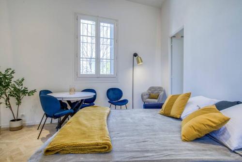 een slaapkamer met een bed met blauwe stoelen en een tafel bij 4 stars Palais Hermitage, 5 pers, AC, Full confort in Nice