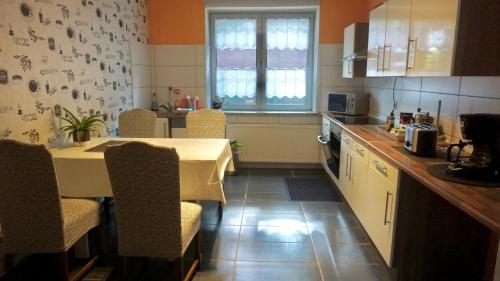 a kitchen with a table and some chairs and a table and a kitchen at Joys Ferienwohnung in Oberhausen