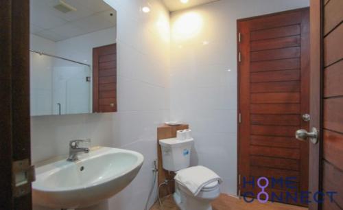 One-Bedroom Apartment في بانغنا: حمام مع حوض ومرحاض ومرآة