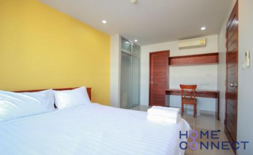 One-Bedroom Apartment في بانغنا: غرفة نوم بسرير ابيض ومكتب