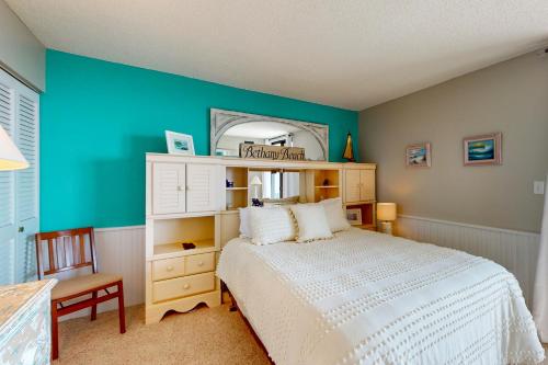 Un dormitorio con una cama blanca y una pared azul. en Sea Colony --- 205N Edgewater, en Bethany Beach