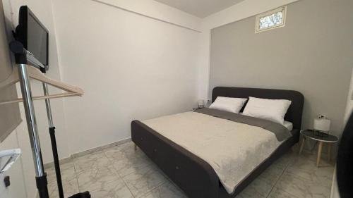 a bedroom with a bed and a television in it at Blue Mind House in Néa Kíos