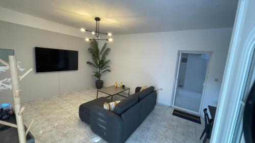 a living room with a couch and a flat screen tv at Blue Mind House in Néa Kíos