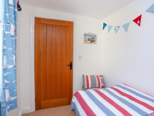 a bedroom with a bed and a wooden door at Bryn Derwen in Valley