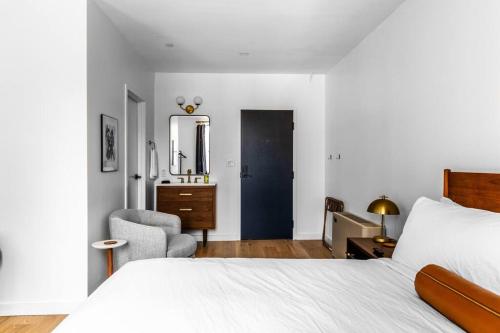 1 dormitorio con cama, silla y espejo en King Bed, Fiber Internet, Heart of Bangor, 50 Roku TV, Room # 208, en Bangor
