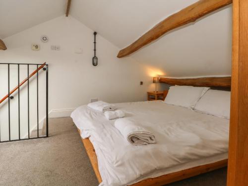 a bedroom with a bed with white sheets and towels at Blencathra Barn in Penrith