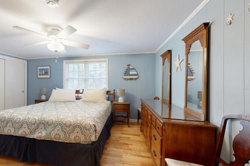 a bedroom with a bed and a dresser and a mirror at Meet Me At Sea in York