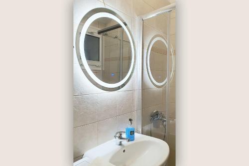 baño con lavabo y 2 espejos en Casa Kali 2 Apartment en Heraclión