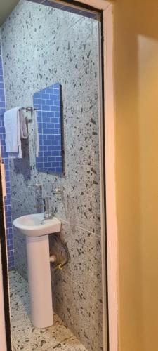 baño con lavabo y pared de azulejos azules en Mindyourbusiness villa en Abuja