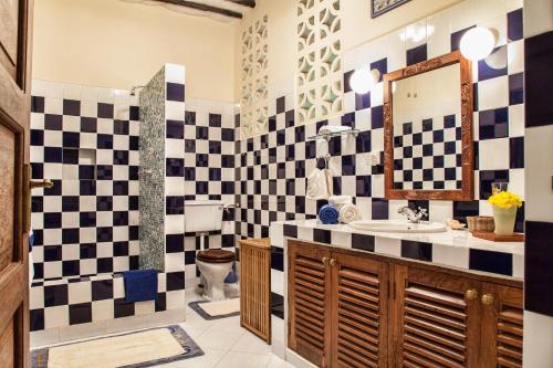 a bathroom with black and white checkered wall at Diani Villa in Diani Beach