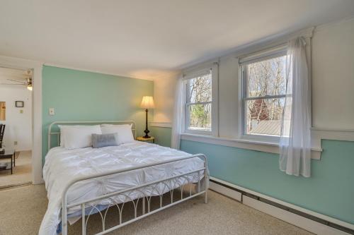 ein Schlafzimmer mit einem Bett und zwei Fenstern in der Unterkunft Oakland Apt on Messalonskee Lake with Dock Access! in Waterville