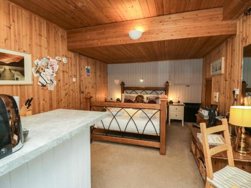 Lake Lodge Studio في باونيس أون وينديرمير: غرفة نوم بسرير في غرفة بجدران خشبية