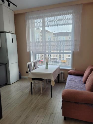 a living room with a table and a large window at ЖК Apple City 1 СПАЛЬНЯ in Prigorodnyy