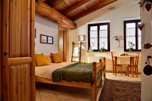 Rifugio Lou Lindal في Canosio: غرفة نوم بسرير وطاولة في غرفة
