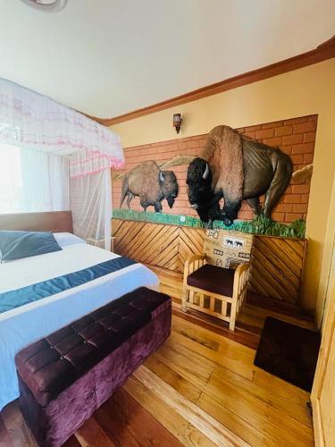 カセセにあるGator's Hotel Kaseseのベッドルーム1室(ベッド1台付)が備わります。壁には動物の壁画が飾られています。