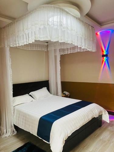 a bedroom with a bed with a white canopy at Gator's Hotel Kasese in Kasese