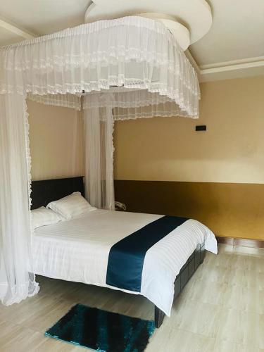 ein Schlafzimmer mit einem großen Bett mit Baldachin in der Unterkunft Gator's Hotel Kasese in Kasese
