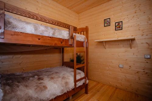 a bedroom with two bunk beds in a cabin at Shpija Ujevara e Vogel in Theth
