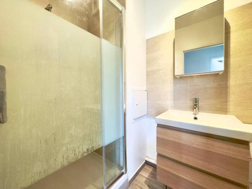 La salle de bains est pourvue d'un lavabo et d'une douche en verre. dans l'établissement Tres Bel Appartement 6P Terasse - Levallois, à Levallois-Perret