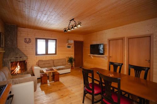 a living room with a couch and a table and a fireplace at Shpija Ujevara e Vogel in Theth